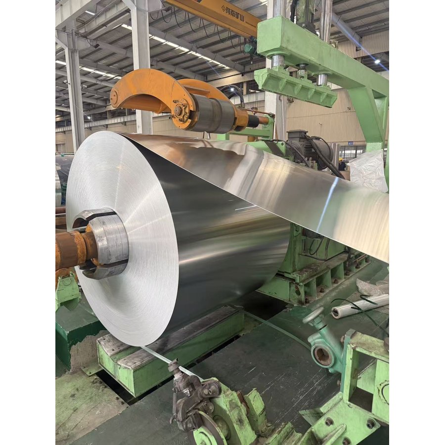 Aluminum coil being processed on rolling machine