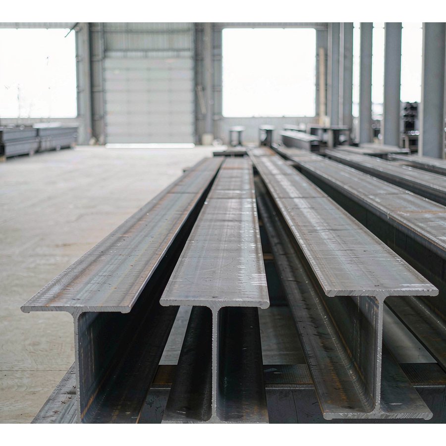Steel I beams stacked inside factory workshop